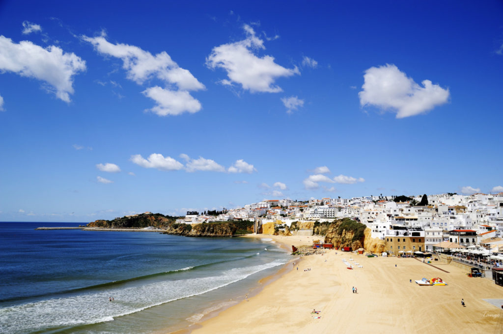 The sun beams down from a blue sky on the beach in Albufeira.